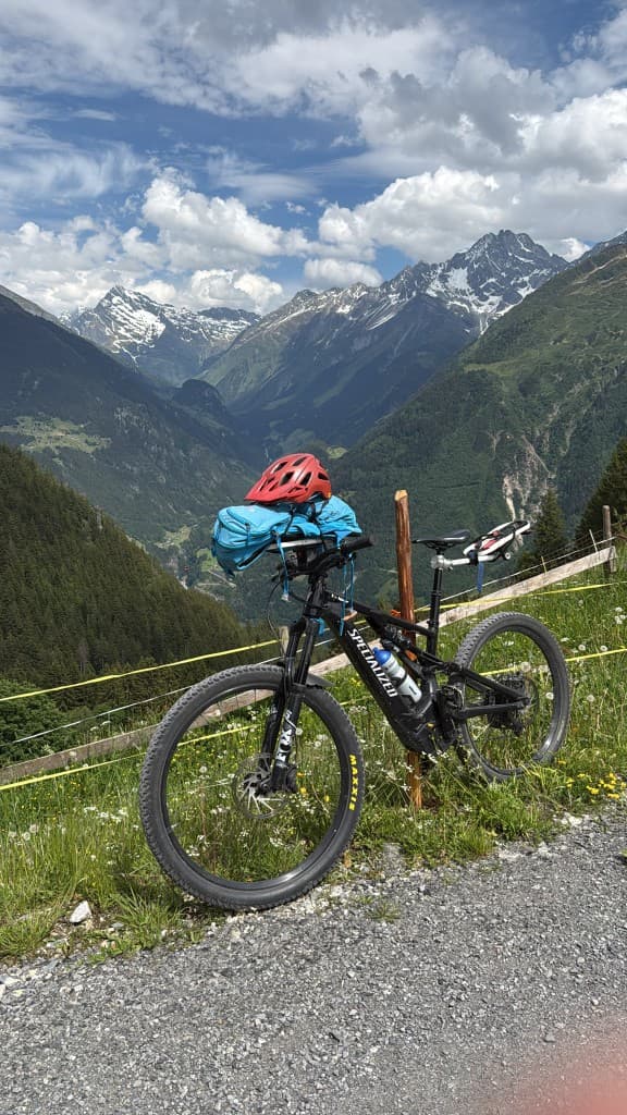 Specialized Mountainbike mit Rucksack am Lenker vor Bergpanorama