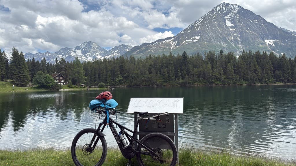 E-MTB am Bergsee mit Schneegipfeln und Berghütte